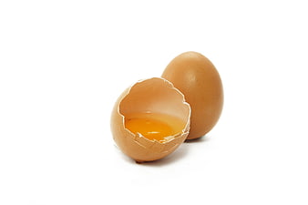 Cracked Brown Egg With Yolk And Whole Egg On White Background