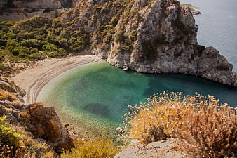 Secluded Mediterranean Cove with Turquoise Waters and Rocky Cliffs