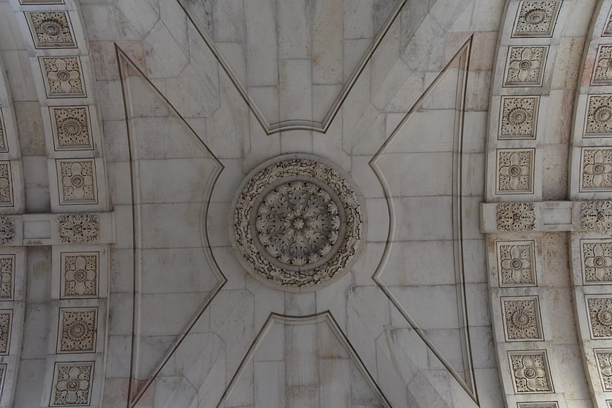 Intricate white marble ceiling with floral rosette and geometric patterns