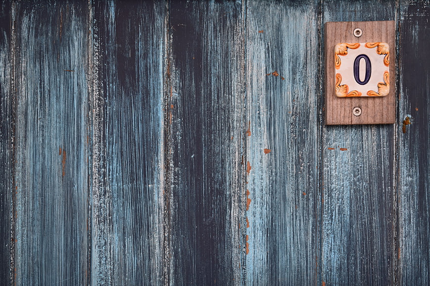 Vintage wooden wall with ceramic number zero plaque