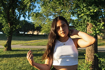 Young Woman in White Top Standing in Park