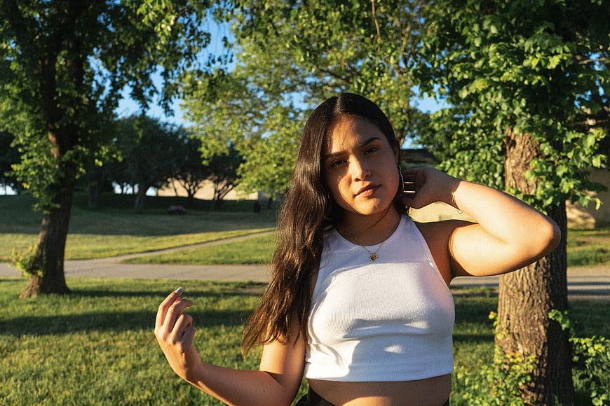 Young Woman in White Top Standing in Park