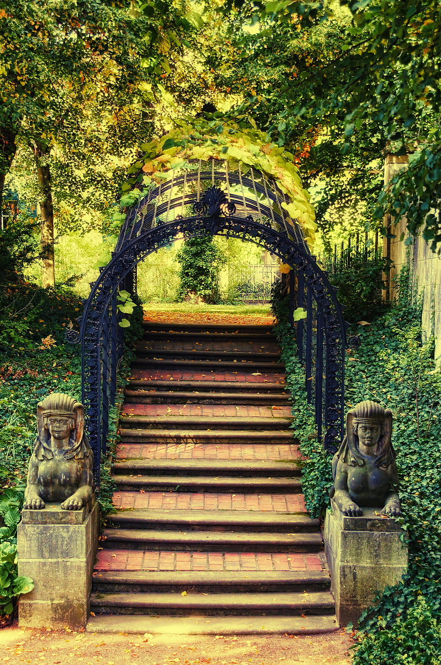 Ornate Garden Archway With Sphinx Statues And Stone Staircase