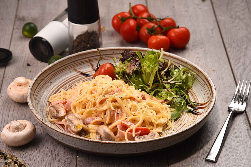 Creamy Mushroom Pasta with Salad on Rustic Wooden Table
