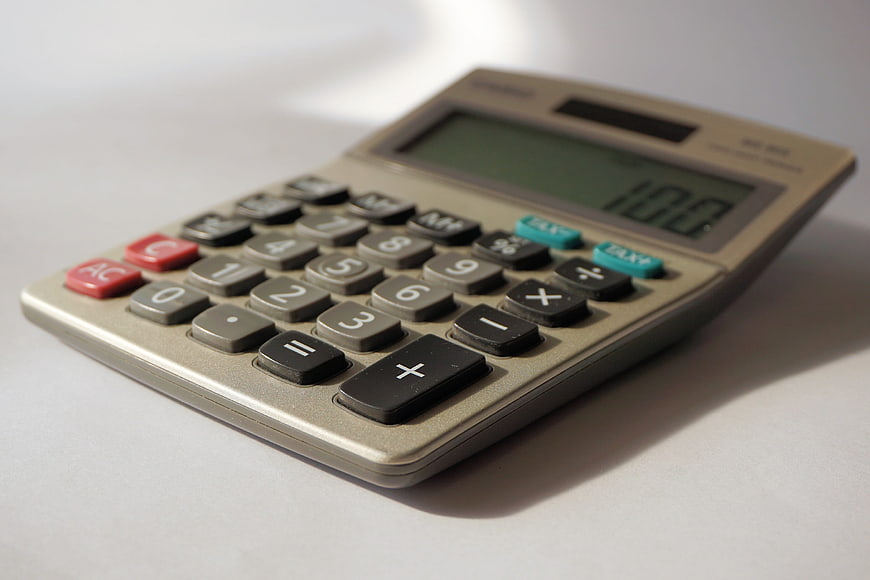 Close-up of beige calculator on white surface