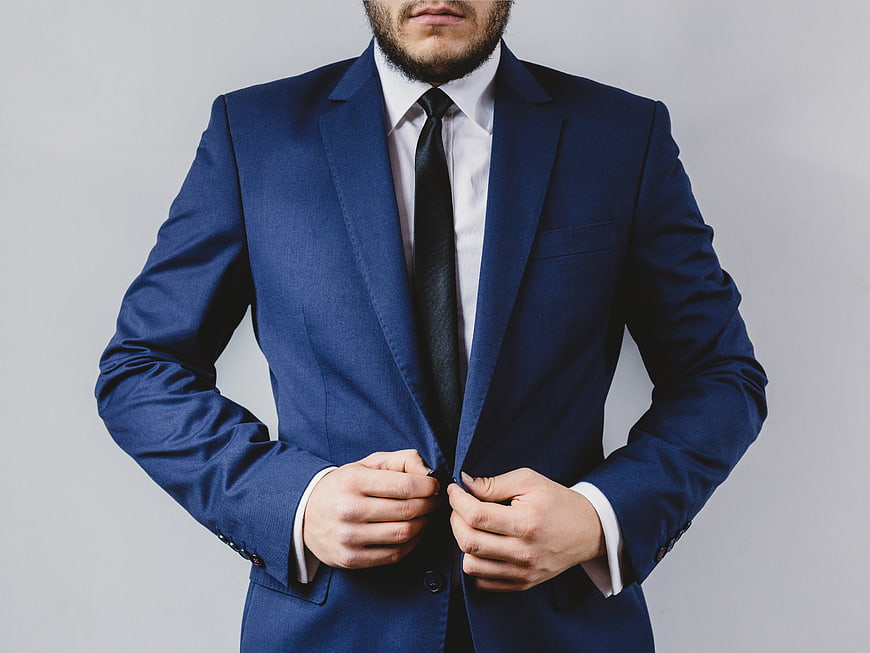 Man in Blue Suit Buttoning Jacket