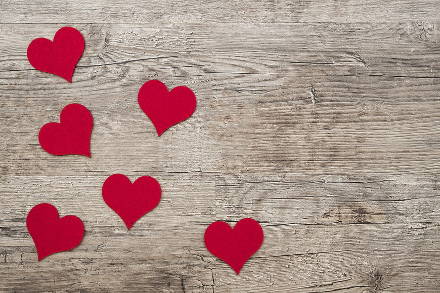 Red felt hearts on rustic wooden background with copyspace