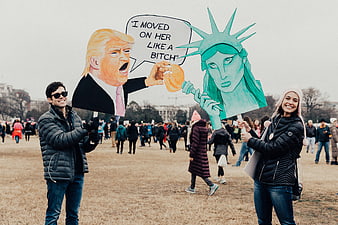 Protesters holding political satire signs at rally