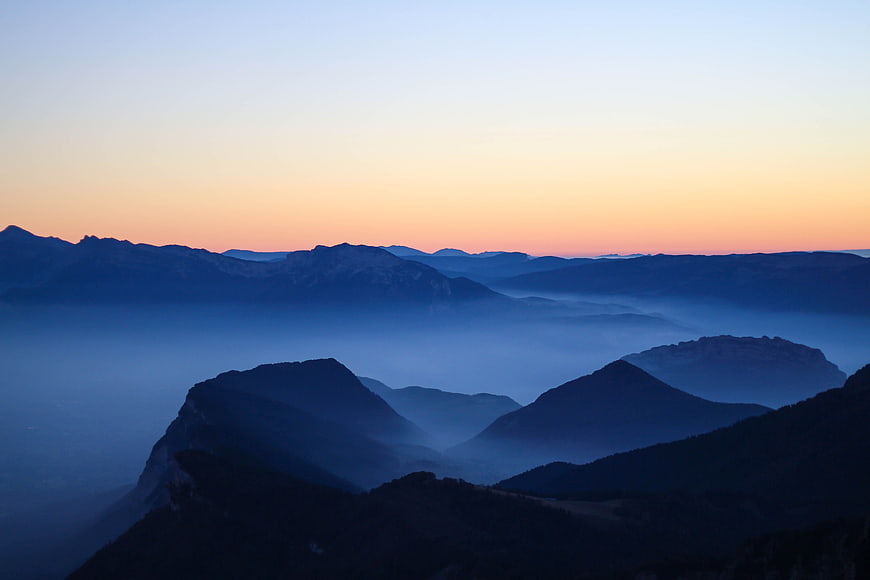 Misty mountain landscape at dawn with blue hour fog
