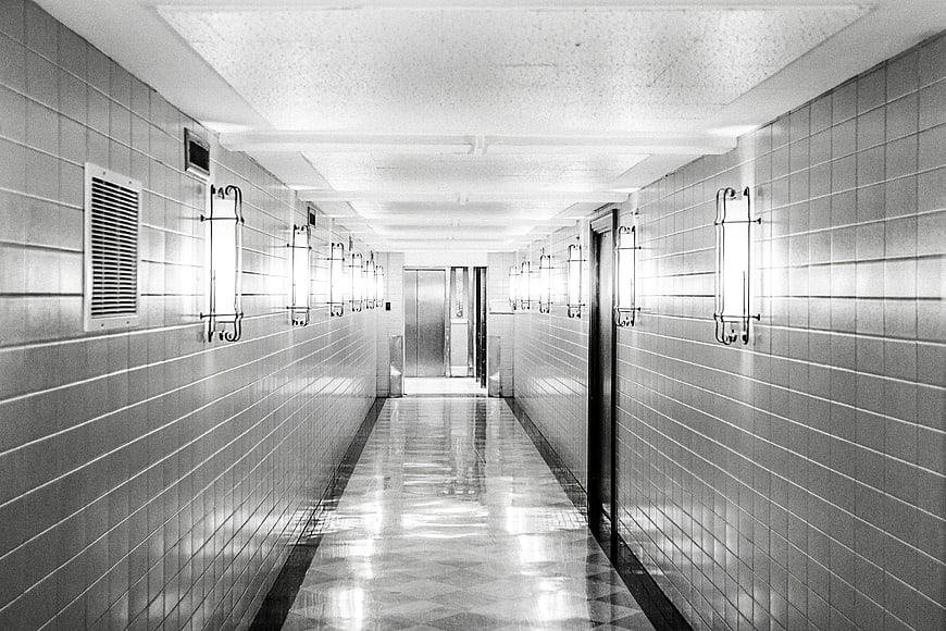 Symmetrical black and white tiled hallway with elevator