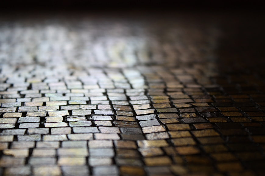 Close-up of wet cobblestone pavement texture at night