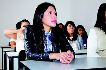 Young woman in leather jacket attending a classroom lecture