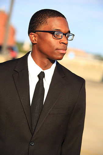 Young African American man in black suit and glasses