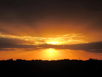 Dramatic orange sunset over suburban silhouette