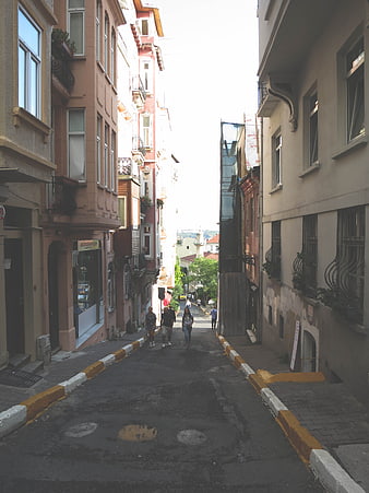 Narrow steep street in Istanbul with pedestrians and colorful buildings