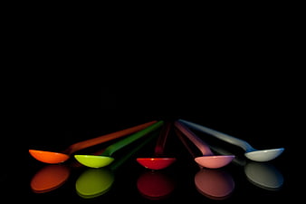 Colorful Plastic Spoons Arranged on Black Background