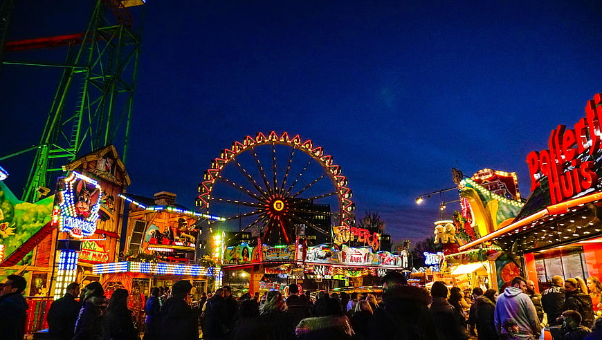 Vibrant Night Scene at a Busy Traveling Carnival with Ferris Wheel