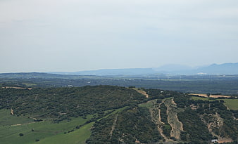 Aerial View of Rolling Green Hills and Forested Landscape