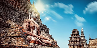 Ancient Buddha Statue at Ayutthaya Ruins with Sun Flare