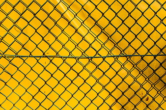 Green chain link fence against vibrant yellow background texture