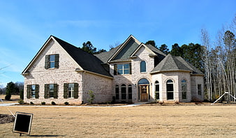 New Brick Home Exterior With Dormer Windows And Blue Sky
