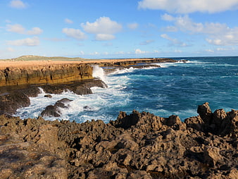 Rugged coastal cliffs with crashing waves and blue ocean