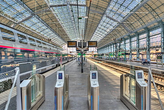 Modern train station platform with silver high-speed train