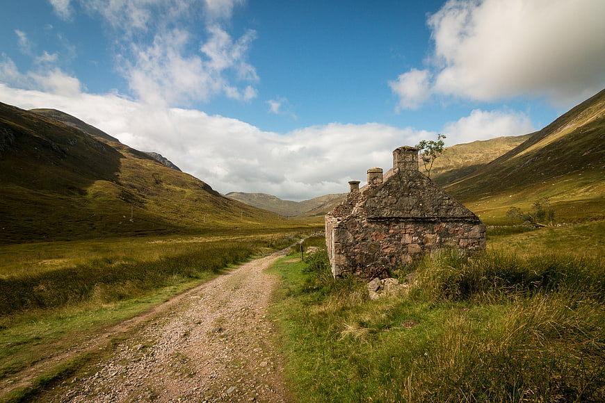 Old stone cottage on a dirt path in the Scottish Highlands
