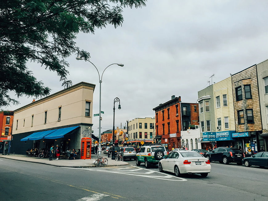 Street view of Bedford-Nassau Ave in Brooklyn with shops and cars