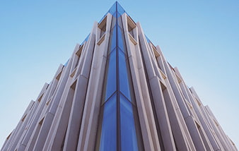 Low angle view of modern skyscraper with blue glass facade