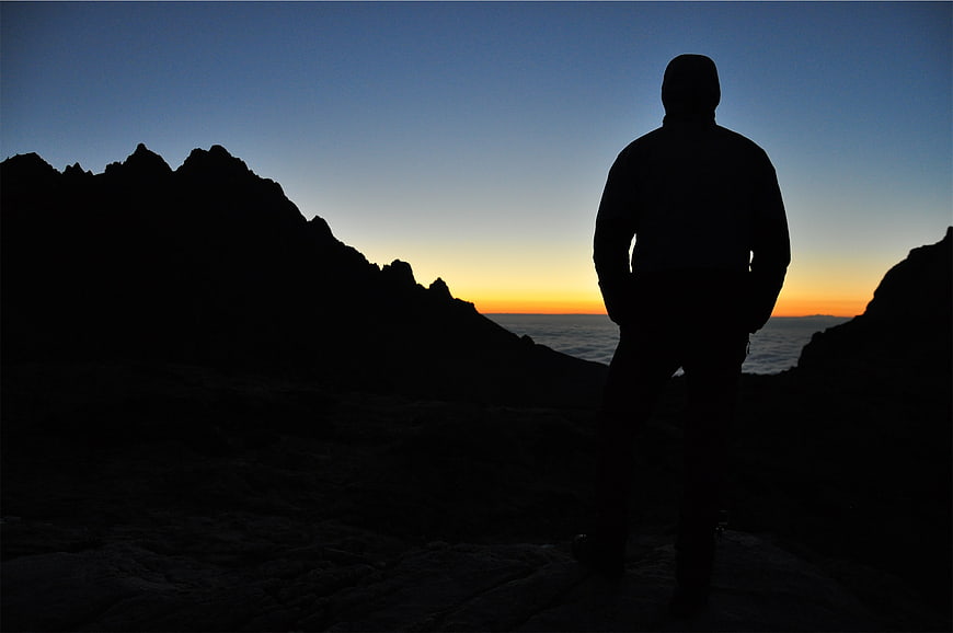 Silhouette of Man Standing on Cliff at Sunset
