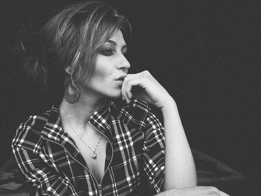 Black and white portrait of a thoughtful woman in plaid shirt