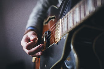 Close-up of musician playing electric guitar with pick