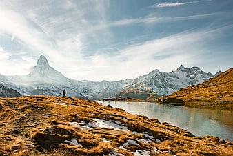 Hiker overlooking alpine lake with Matterhorn mountain view