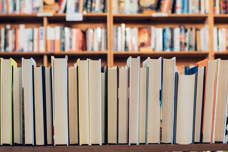 Close-up of books on a wooden library shelf