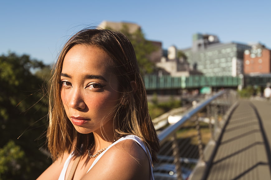 Portrait of young woman on urban bridge in sunlight