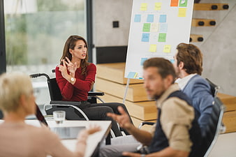 Woman in wheelchair leading business meeting with team