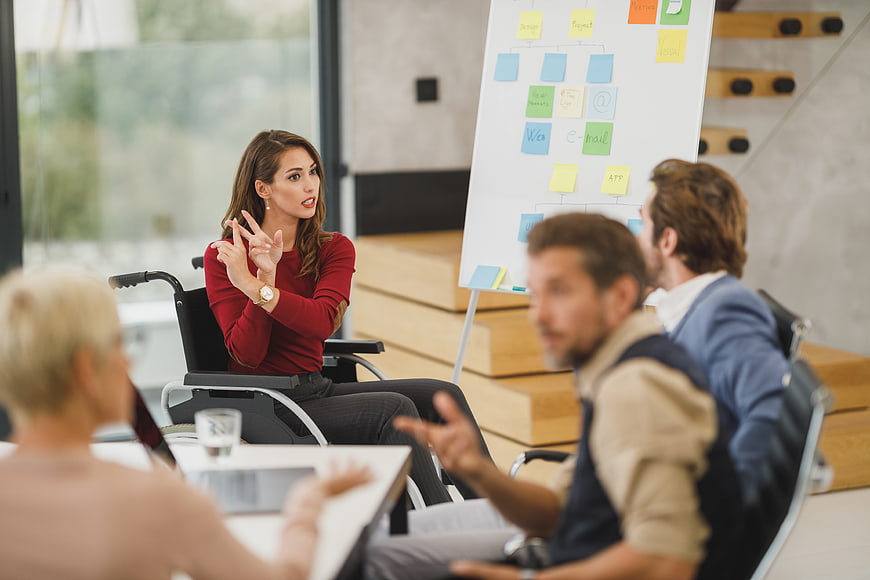 Woman in wheelchair leading business meeting with team