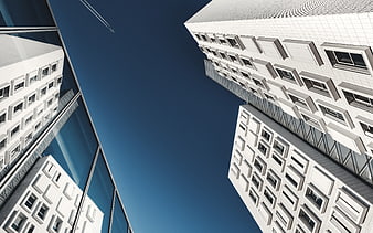 Low angle view of modern white skyscrapers against blue sky