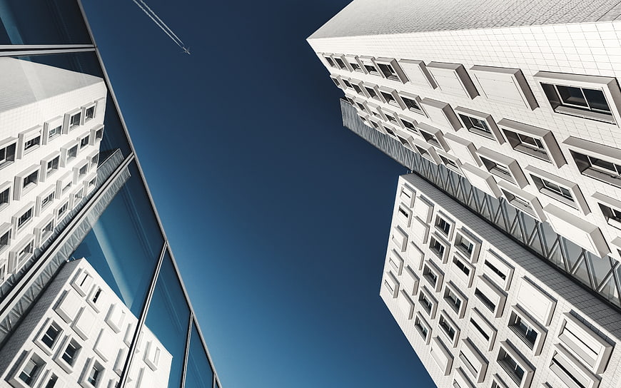 Low angle view of modern white skyscrapers against blue sky