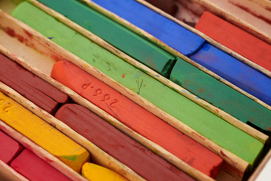 Close-up of colorful pastel chalk sticks in wooden box