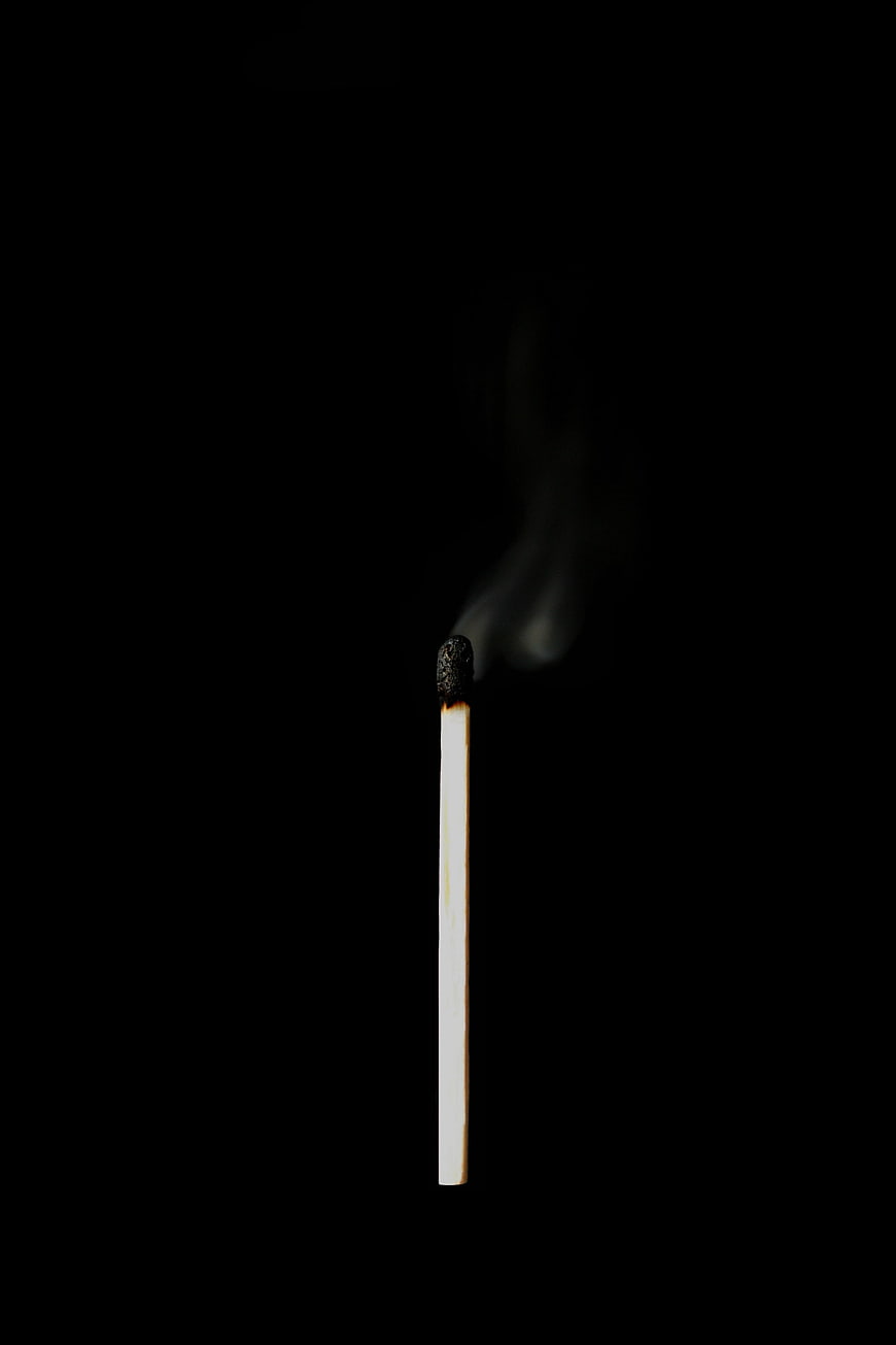 Burned Matchstick With Smoke Against Black Background