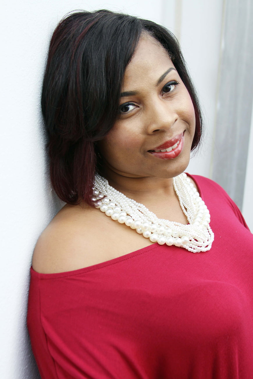 Confident Black Woman in Red Top with Pearl Necklace