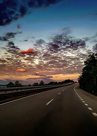 Empty Highway at Sunset with Dramatic Clouds