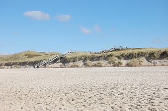 Sandy Beach with Wooden Stairs Leading to Dunes