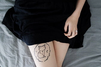 Geometric fox tattoo on thigh with black skirt