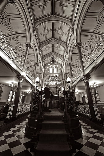 Black and white interior of a grand Victorian mansion with checkered floor