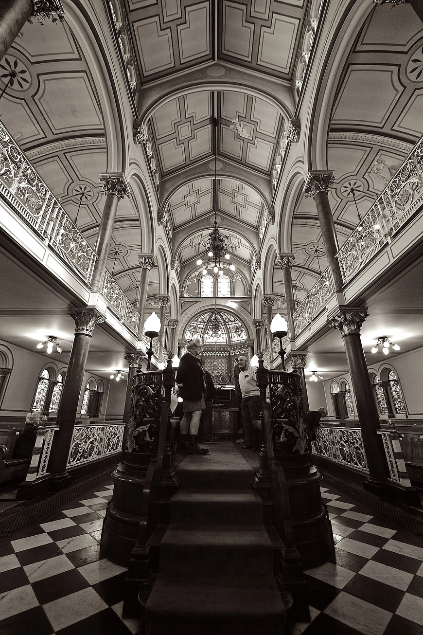 Black and white interior of a grand Victorian mansion with checkered floor