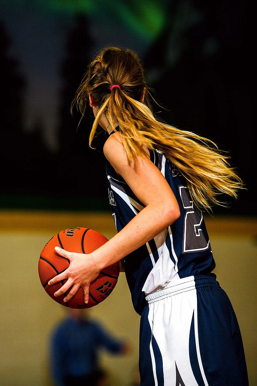 Female Basketball Player Dribbling Ball in Gym