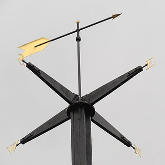 Black and Gold Compass Rose Weather Vane Against Overcast Sky